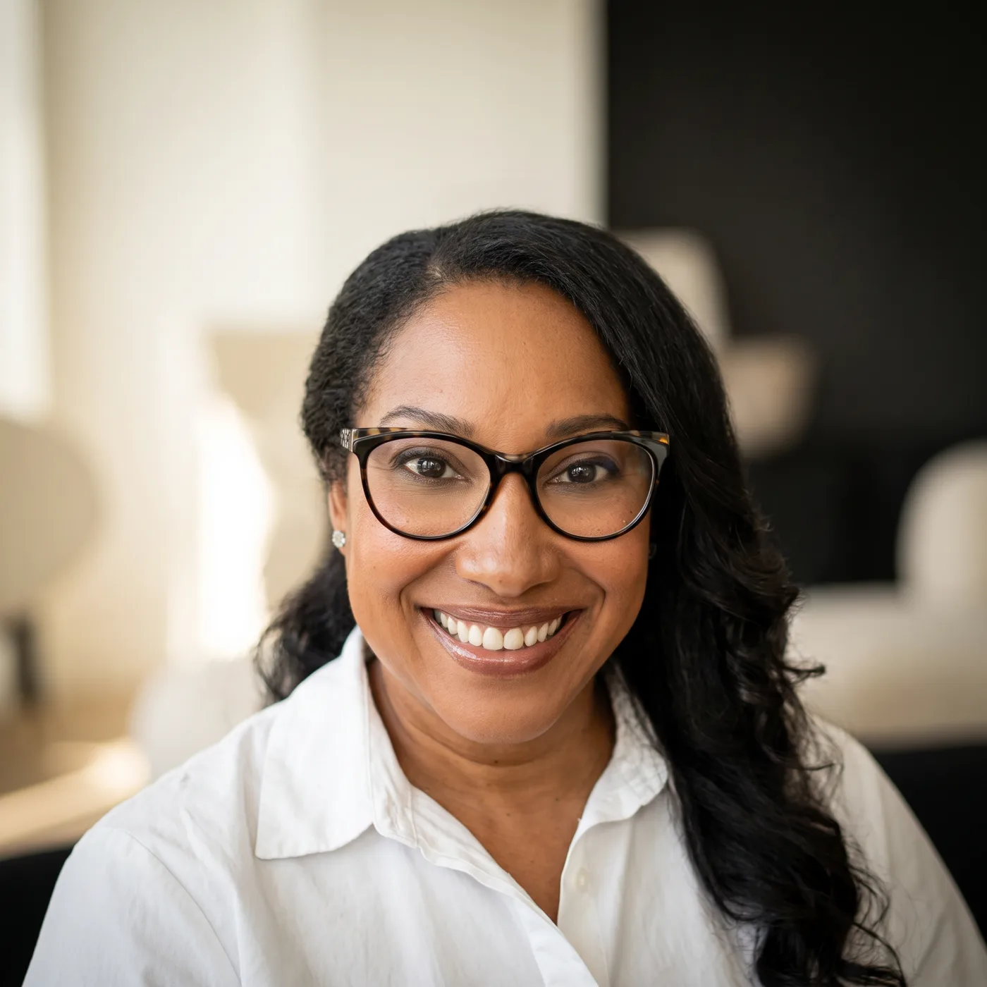Kesi Case smiling at her desk, welcoming you to the conversation
